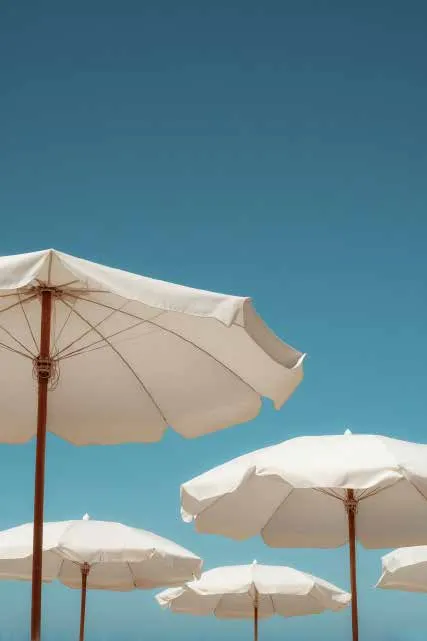 Ombrelloni bianchi di uno stabilimento balneare contro il cielo