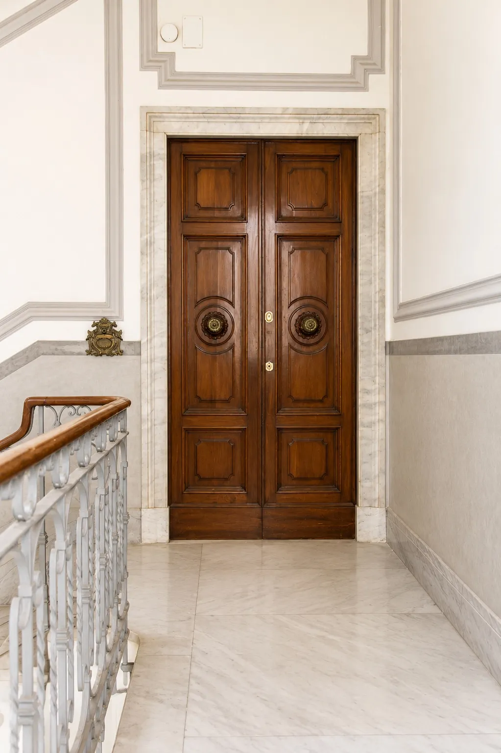 Portoncino d'ingresso in noce sul pianerottolo in marmo
